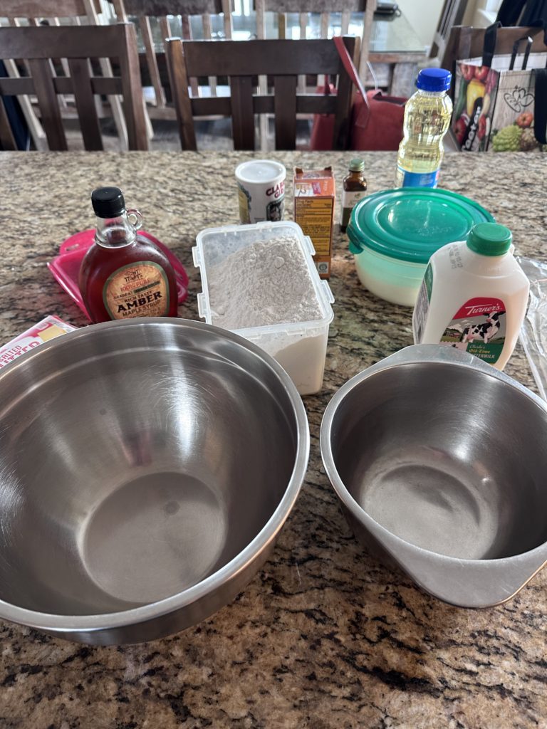Pancake ingredients and mixing bowls on a kitchen counter