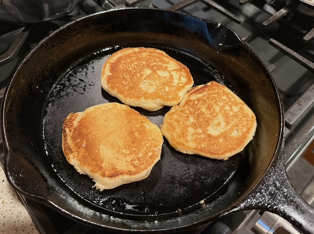vegan pancakes cooking on a frying pan