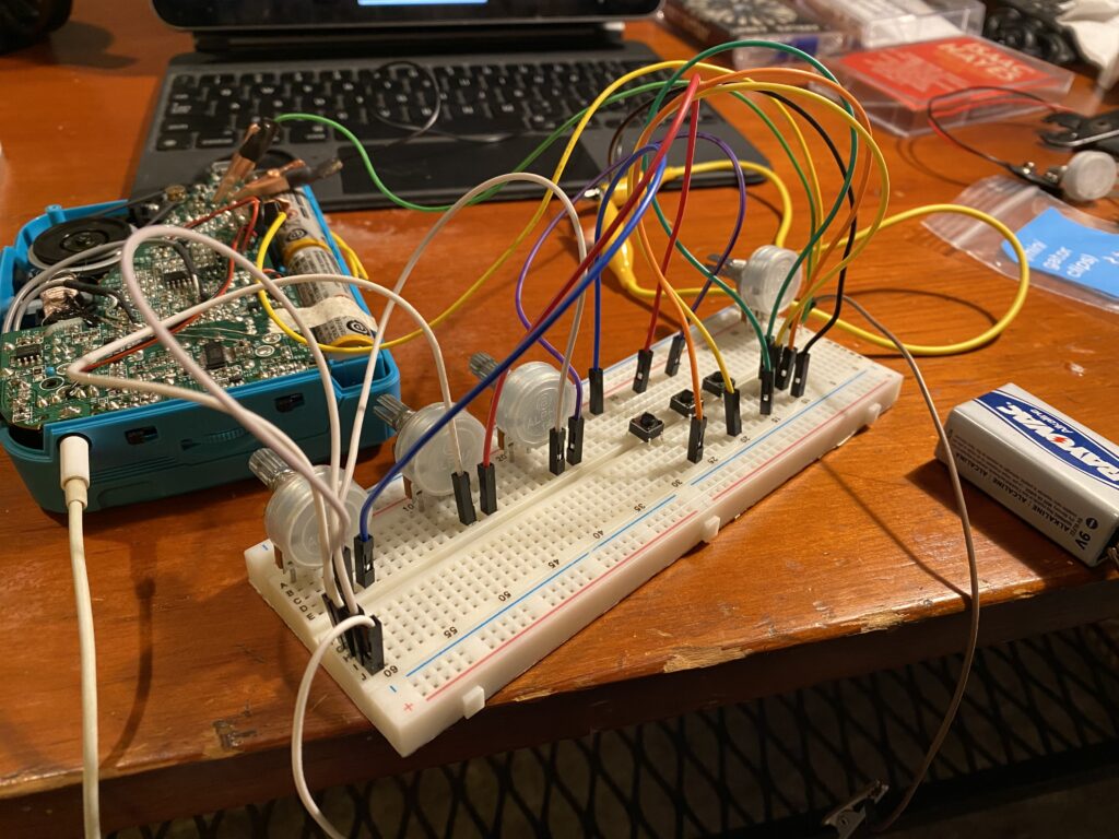 a breadboard with potentiometers, switches, and wires that are connected to contact points on the exposed circuit board of a walkman tape player
